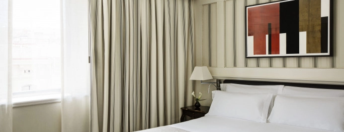 010-deluxe-city-view-dormitorio-con-cama-doble-luz-natural-y-cortinas-a-rayas.jpg