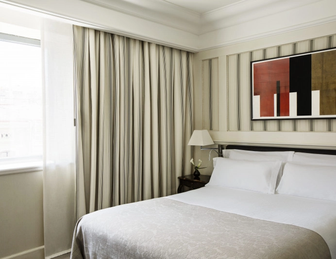 010-deluxe-city-view-dormitorio-con-cama-doble-luz-natural-y-cortinas-a-rayas.jpg