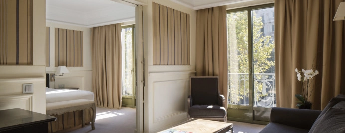 00-junior-suite-paseo-de-gracia-salon-con-sofa-ventanal-luz-natural-y-acceso-a-dormitorio.jpg