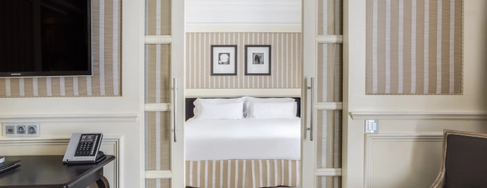 03-junior-suite-paseo-de-gracia-dormitorio-cama-doble-pared-rayas-puertas-correderas-tv-y-escritorio.jpg