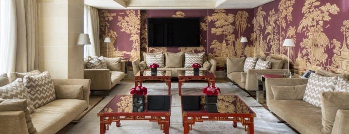 02-royal-penthouse-sala-estar-sofas-beige-mesas-rojas-tv-mural-oriental.jpg