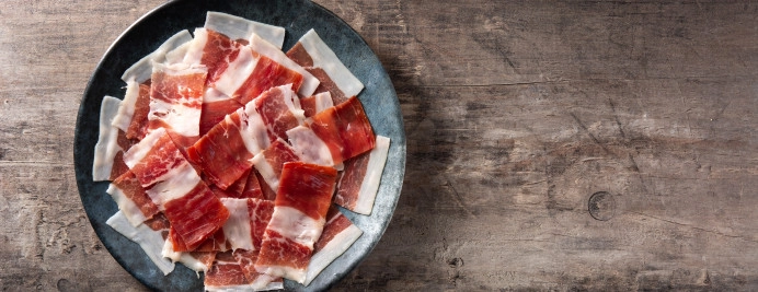 spanish-serrano-ham-slices-black-plate-wooden-table.jpg